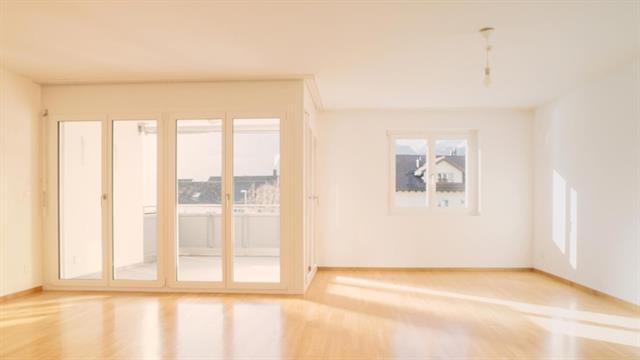 ein Zimmer mit Holzboden und einer großen Glastür